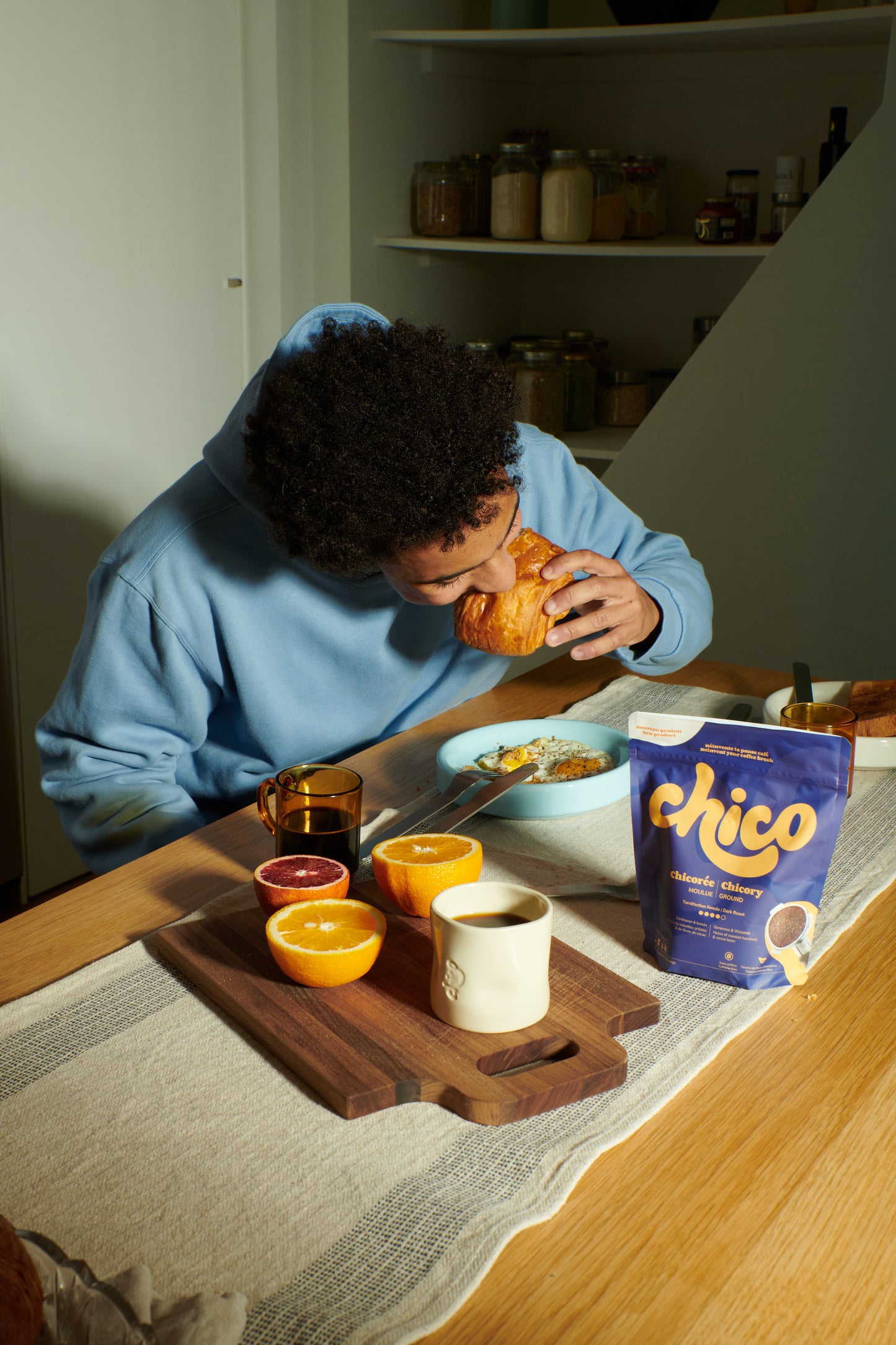 Homme qui mange une chocolatine le matin avec sa tasse de chicoree Chico