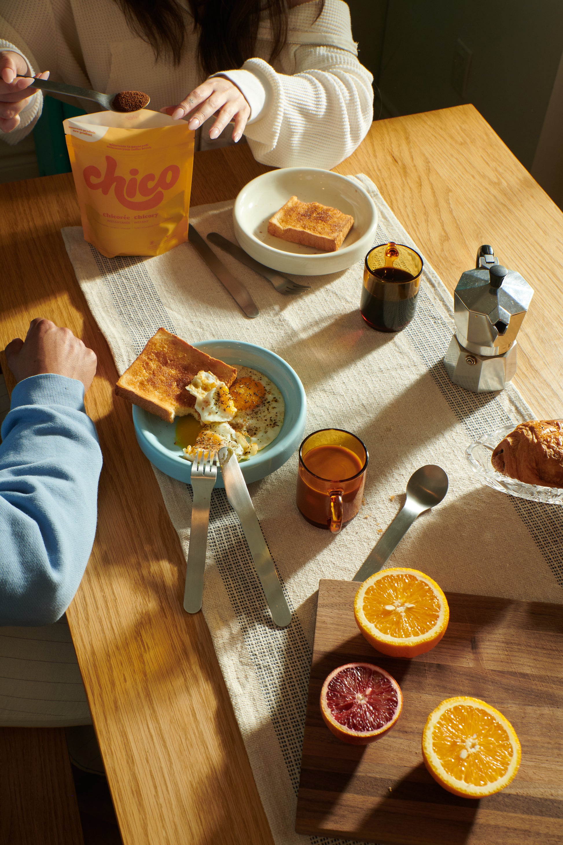 Petit déjeuné du matin avec la chicorée instantanée Chico. Table avec des oeufs, des fruits et du pain