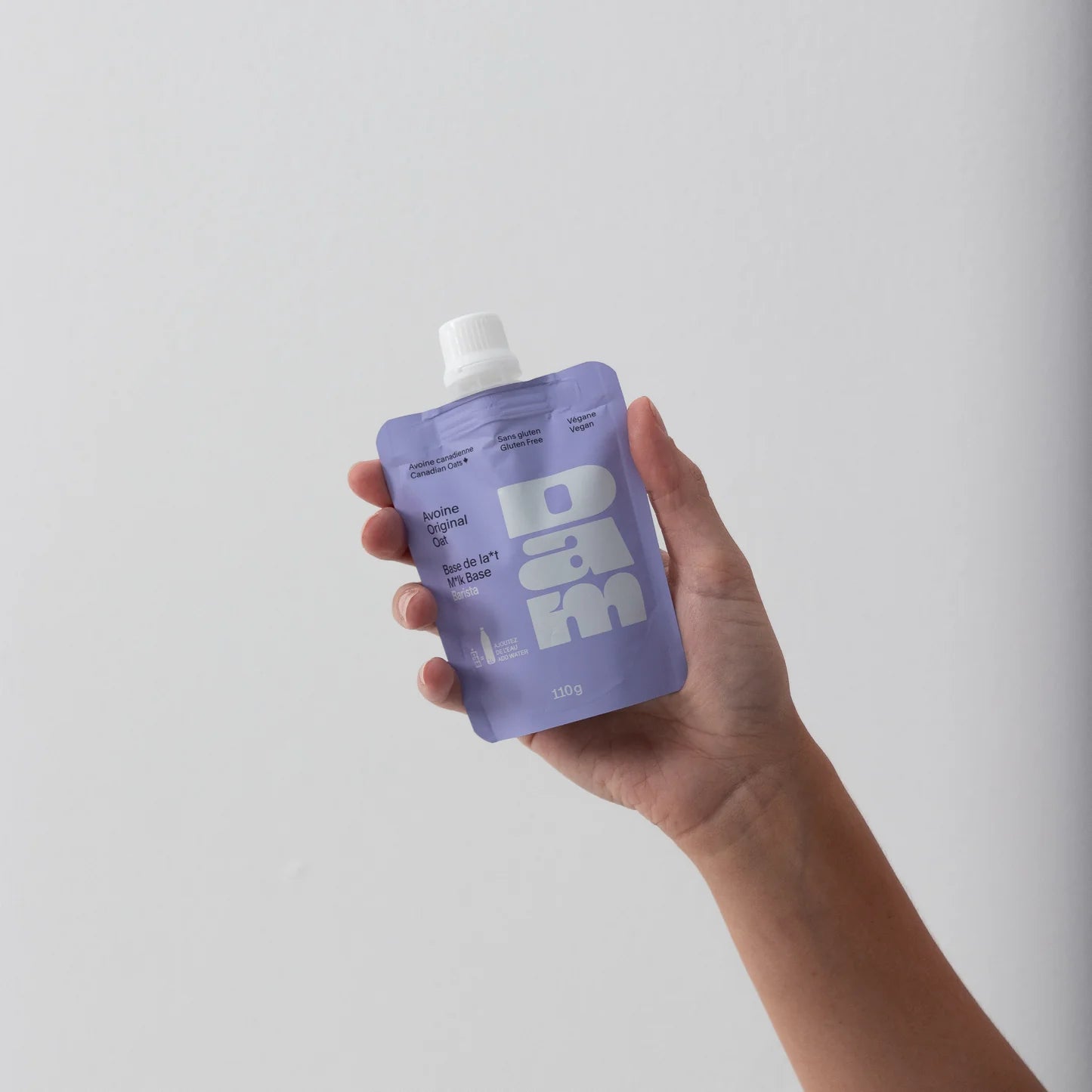 Tube de lait d'avoine 1 litre tenu dans la pain d'une personne