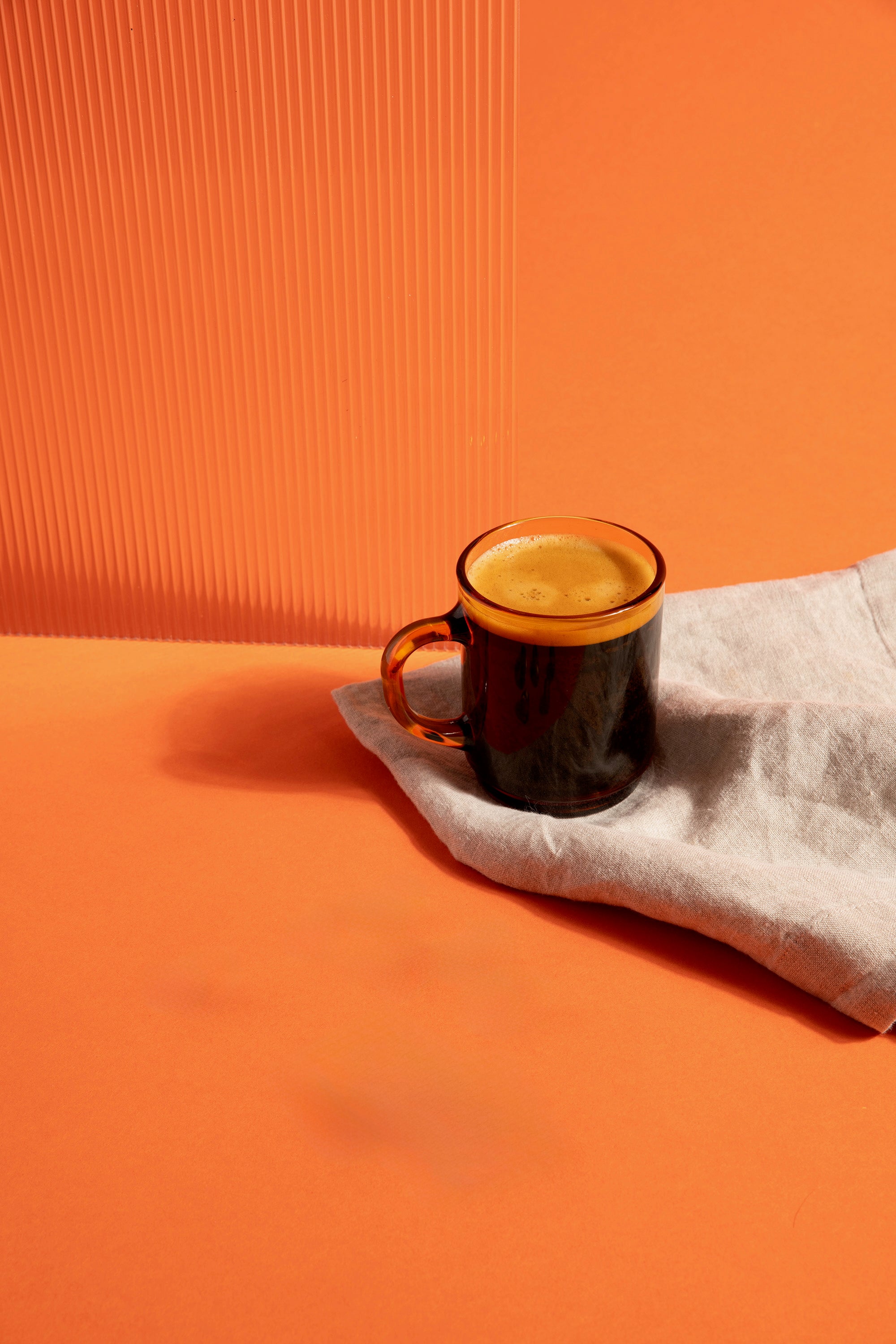 Tasse de chicoree Chico posée sur une serviette sur fonds orange