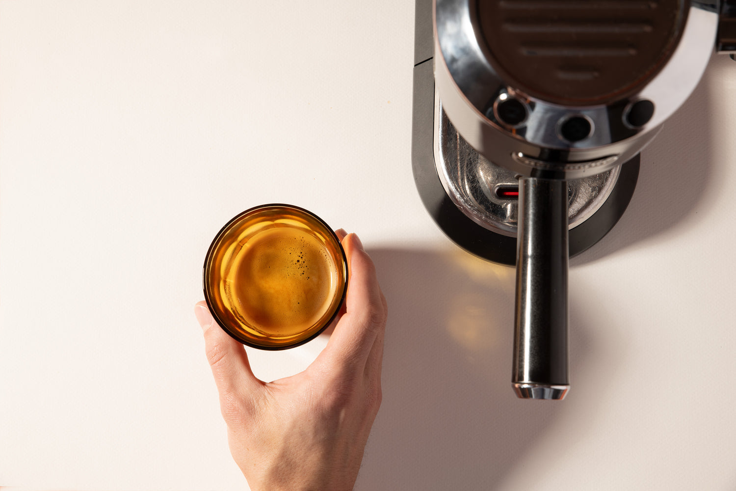 Vue du dessus d'une machine espresso avec une tasse de chicorée a coté. On voit un léger créma sur le dessus de la tasse