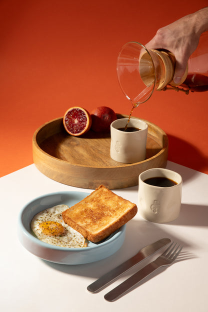 Petit déjeuné avec des oeufs, du pain, une orange et de la chicorée